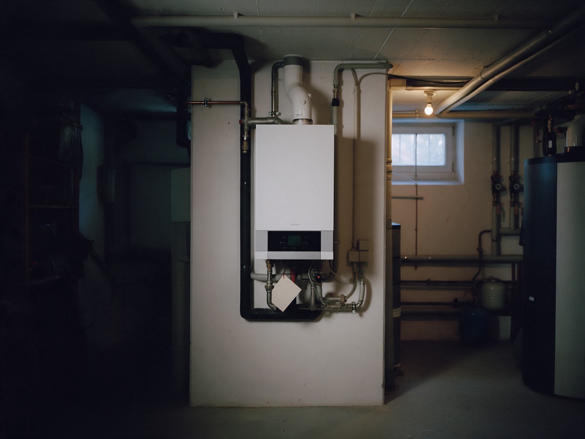 Gastherme im Heizungskeller mit leerem Wartungsanhänger